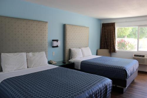 a hotel room with two beds and a window at Torch Lite Lodge in Yuma