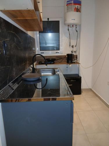a kitchen with a counter with a sink and a tv at Monoambiente en el centro de Zarate in Zárate