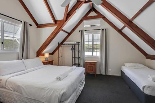 two beds in a room with two windows at Amity Oasis in Amity Point