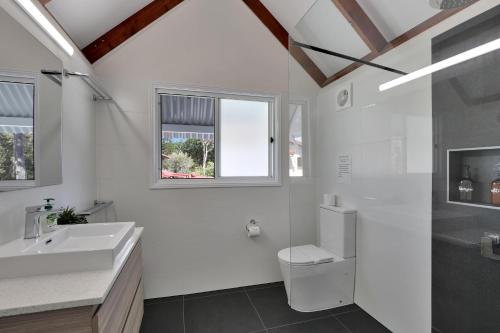 a white bathroom with a sink and a toilet at Amity Oasis in Amity Point