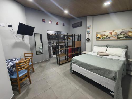 a bedroom with a bed and a table and a chair at Villa São Lourenço in Bertioga