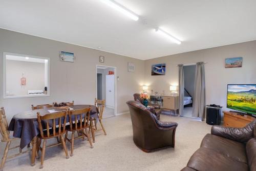 a living room with a table and a dining room at Betty's Place in Amity Point