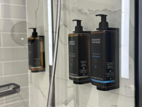 a group of three soap dispensers on a wall in a bathroom at Hotel Mercure Poznań Centrum in Poznań