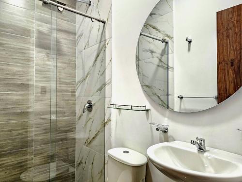 a bathroom with a toilet and a sink and a mirror at Hotel Casa Cristales in Cali