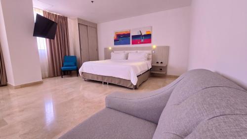 a hotel room with a bed and a couch at Radisson Diamond Barranquilla in Barranquilla