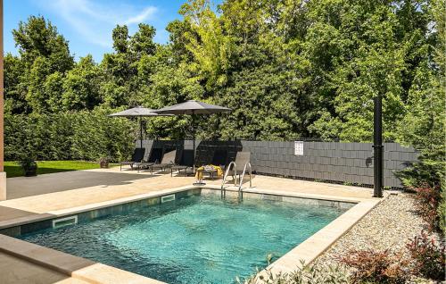 a swimming pool with chairs and an umbrella at Stunning Home In Krsan in Kršan