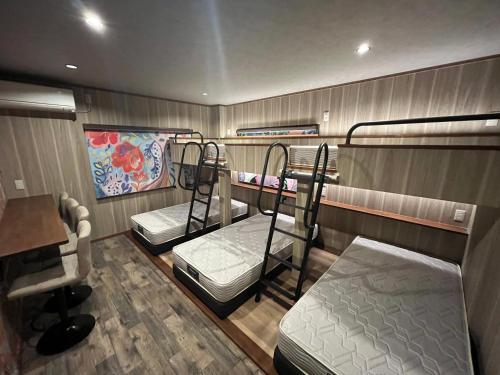 a room with three bunk beds and a desk at 安全な個室貸切に広々した共用スペースの喜久屋コテージクレア in Yamanakako
