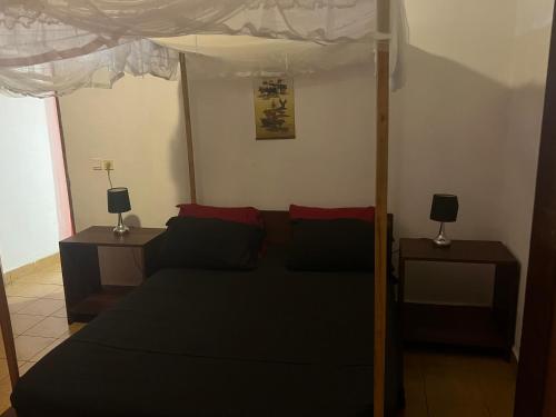 a bedroom with a bed and two night stands at Villa CALI Napa in Sambava