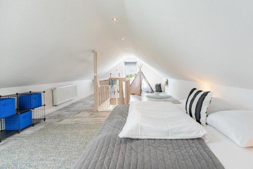 a bedroom with a large bed and a staircase at Cottage am Deich Whg Marlene in Uelvesbüll