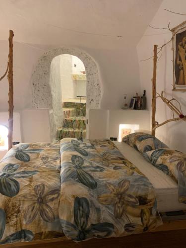 a bedroom with a bed with a floral comforter at La Gata Negraa in Bácor
