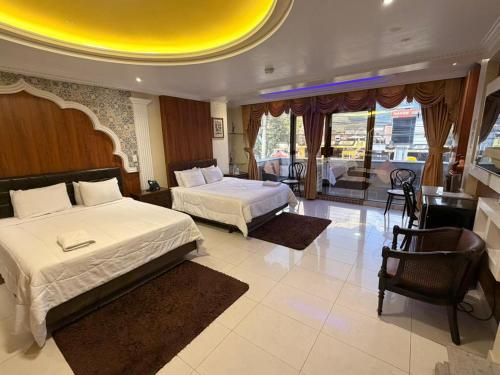 a bedroom with two beds and a living room at Hotel Troya in Ibarra