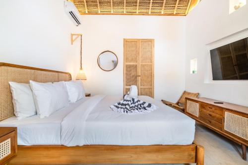 a bedroom with a bed and a desk at Villa Anak Ikan in Gili Islands