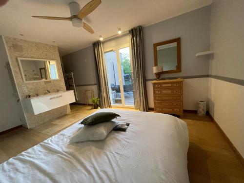 a bedroom with a white bed with a ceiling fan at 15 min from Lyon Fresh Peaceful Room with Pool and Garden in Dardilly