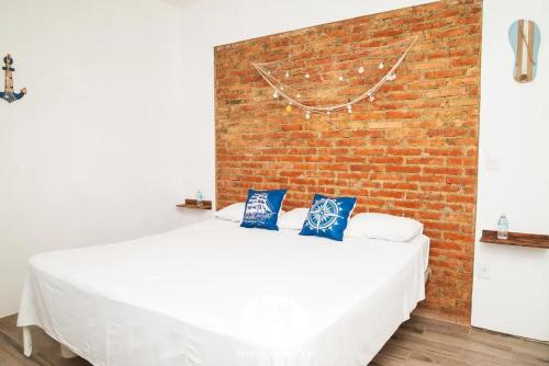 ein weißes Bett in einem Zimmer mit einer Backsteinwand in der Unterkunft Hotel Punta Cometa Tecolutla in Tecolutla