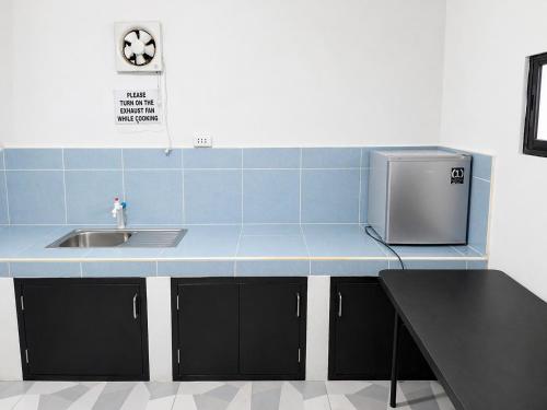 a kitchen counter with a sink and a microwave at YANTO BEACH HAUS at CAGWAIT WHITE BEACH in Cagwait