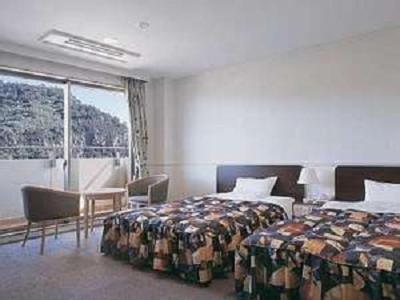 a hotel room with two beds and a large window at Ibusuki Kokoronoyado in Ibusuki