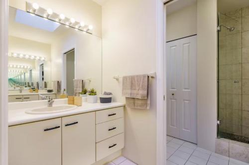 a white bathroom with a sink and a shower at Bright and Spacious Upper Level House, Great Area in North Vancouver