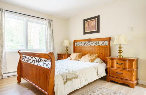 a bedroom with a wooden bed and a window at Bright and Spacious Upper Level House, Great Area in North Vancouver