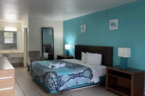 a bedroom with a bed and a blue wall at APM Inn & Suite in Jacksonville