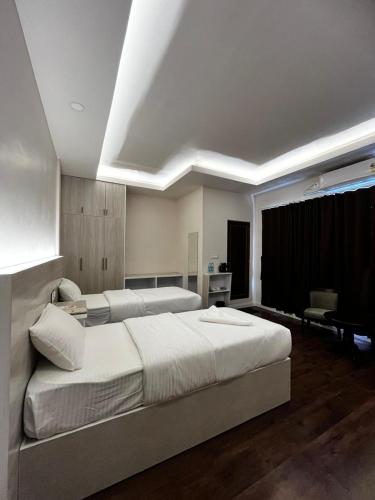 a bedroom with a large white bed and a couch at The View Hotel Falkland in Āīzawl