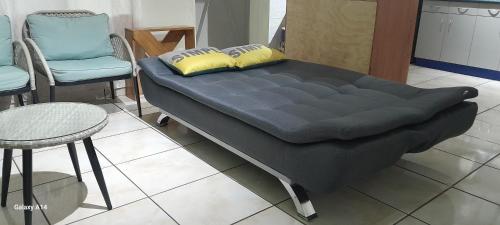 a bed in a room with two chairs and a table at Isabela´s Quality Accommodation in San Salvador