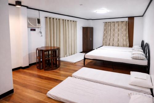 a small room with two beds and a table at YANTO BEACH HAUS at CAGWAIT WHITE BEACH in Cagwait