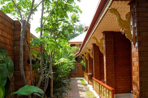 a brick building with a walkway leading into a garden at Irawadee Resort in Mae Sot