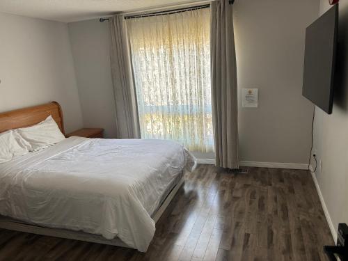 a bedroom with a bed and a large window at Cozy room in Kitchener