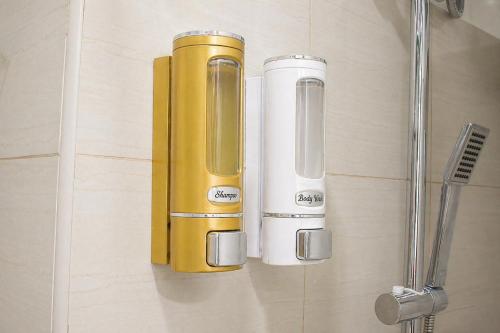 a bathroom with a yellow dispenser on the wall at Cozy 619 1BR Shore2 Residence, Near Airport, IKEA, MOA, SMX, Pasay City, Manila in Manila