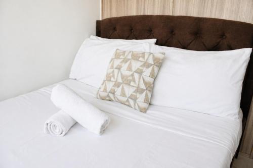 a white bed with a pillow and two towels on it at Cozy 619 1BR Shore2 Residence, Near Airport, IKEA, MOA, SMX, Pasay City, Manila in Manila