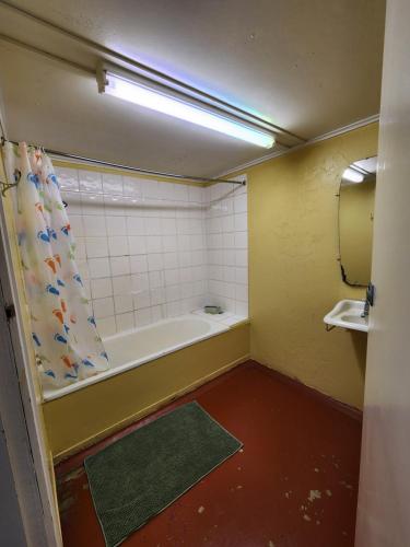 a bathroom with a bath tub and a sink at Hotel Cecil Wondai in Wondai