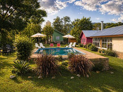 a backyard with a pool and chairs and a house at Cabañas equipadas en Vaqueros - naturaleza y tranquilidad cerca de Salta in Vaqueros