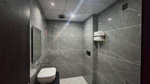 a bathroom with a shower with a toilet and a sink at Raja Krishna Mahal in Kushinagar