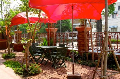 a table and chairs under an umbrella on a patio at Irawadee Resort in Mae Sot