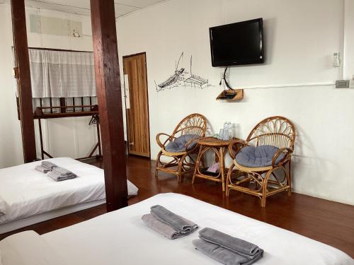 a room with two beds and a table and chairs at เชียงคานคลาสสิค in Chiang Khan