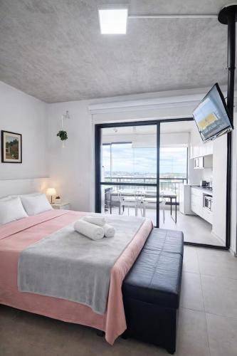 a bedroom with a bed and a balcony with a television at Studio Aurora, Bom Retiro - Anhembi - Com garagem in São Paulo