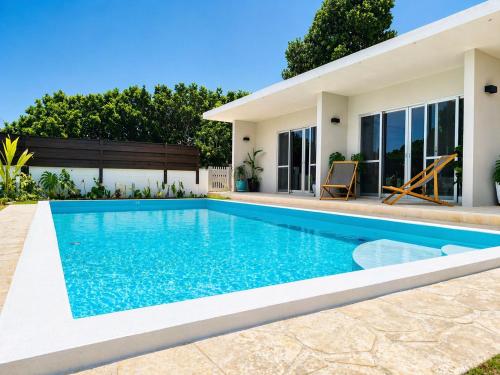 a swimming pool in front of a house at Shiraho Breeze Poolside Villa in Ishigaki Island