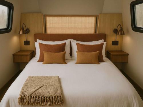 a bedroom with a large white bed with pillows at Caravan Hatta by Our Habitas in Hatta
