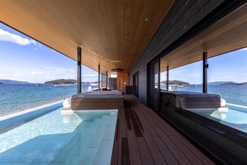 a bedroom with two beds and a view of the ocean at Sunset SPA Resort AJI by SETO CLAS in Takamatsu