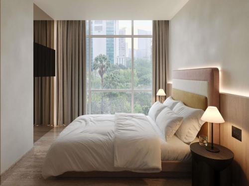 a bedroom with a white bed with a large window at Hyde Mexico City Reforma in Mexico City