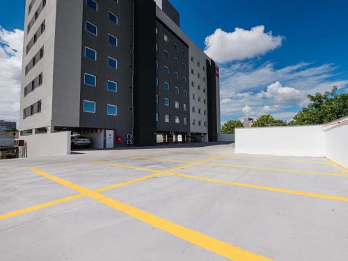 a parking lot in front of a building at ibis Pelotas - Recem inaugurado in Pelotas