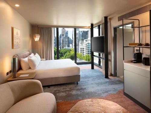 a hotel room with a bed and a large window at Mercure Melbourne La Trobe Street in Melbourne