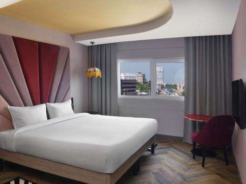 a hotel room with a bed and a window at IBIS STYLES KINSHASA in Kinshasa
