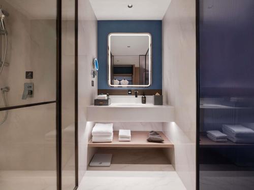 a bathroom with a sink and a mirror at NOVOTEL Zhoushan Luting in Zhoushan