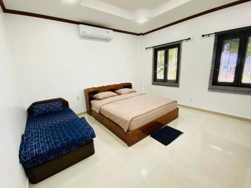 a bedroom with a bed and a blue ottoman at Tha sala beach house in Ban Phang Pling