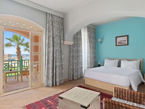a bedroom with a bed and a view of the ocean at Swissotel Resort El Quseir in Quseir