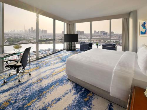 a hotel room with a bed and a large window at Mövenpick Dubai Creek in Dubai