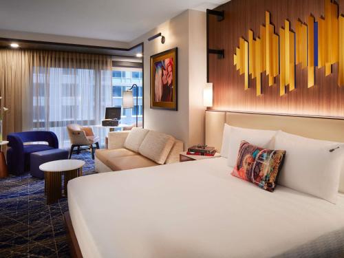 a hotel room with a bed and a living room at Hard Rock Hotel New York - Partner of ALL Accor in New York