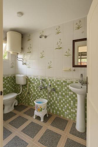 a bathroom with a toilet and a sink at Heritage Rose Inn in Srinagar
