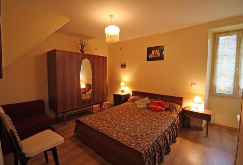 a bedroom with a bed and a mirror and a chair at La bachellerie in Nedde